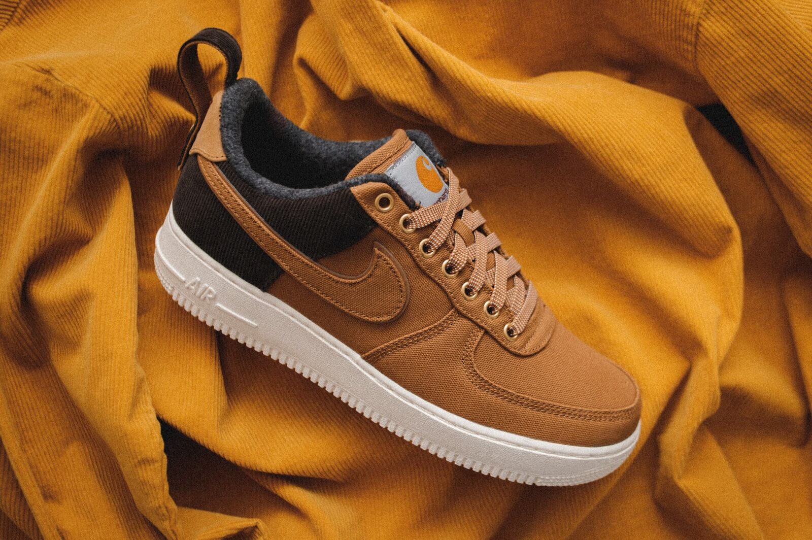 brown Nike sneaker on yellow textile